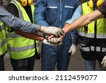 Group of technician engineer or worker in protective uniform with hardhat standing and stacking hands celebrate successful together or completed deal commitment at heavy industry manufacturing factory