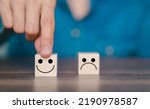 Small photo of customer pointing finger at wooden block smiley face icon customer service concept satisfaction or dissatisfaction with the service Opinion survey, suggestion, criticism, suggestion, evaluation