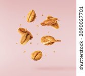 Fresh Granola flakes falling in the air on pink background. Food zero gravity conception. High resolution image