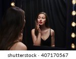 Stunning beauty touching at lipstick in mirror's reflection