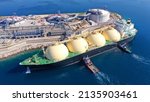 Small photo of Aerial drone photo of LNG (Liquified Natural Gas) tanker anchored in small LNG industrial islet of Revithoussa equipped with tanks for storage, Salamina, Greece