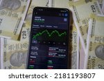 Small photo of Mumbai, india. July 20,2022. indian stock exchange. sensex chart on smartphone display and twenty rupees note background.