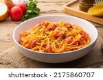 Small photo of Hot dog or sausage stuffed with spaghetti in tomato pork sauce in white plate