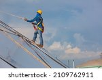 Small photo of Male workers rope access height safety connecting with a knot safety harness, roof fall arrest and fall restraint anchor point systems ready to ascending, construction site oil tank dome