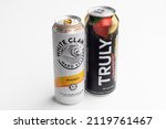 Small photo of Portland, OR, USA - Oct 28, 2021: White Claw Hard Seltzer mango flavored spiked sparkling water, and Truly Hard Seltzer strawberry lemonade spiked and sparkling water isolated on a white background.