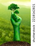 Small photo of Clenched fist hand, raised fist - symbol of victory, Stranglehold by nature and trees, Environment earth day,Concept Save the world, save environment, Forest conservation concept, Protecting nature.