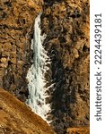 Small photo of Russia. The South of Western Siberia, the Altai Mountains. A frozen waterfall on inaccessible rocks in the valley of the Chulyshman River near the Katu-Yaryk pass.