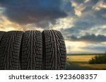 Summer car tires on the blue sky with clouds background.
