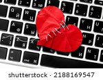Small photo of Red heart paper on keyboard computer background. Online internet romance scam or swindler in website application dating concept. Love is bait or victim.