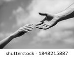 Solidarity, compassion, and charity, rescue. Hands of man and woman reaching to each other, support. Giving a helping hand. Lending a helping hand. Black and white.