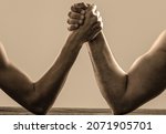 Small photo of Arm wrestling. Heavily muscled man arm wrestling a puny weak man. Arms wrestling thin hand and a big strong arm in studio. Two man's hands clasped arm wrestling, strong and weak, unequal match.
