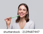 Portrait of a smiling cute woman holding toothbrush. Smiling woman with healthy beautiful teeth holding a toothbrush. Dental health background. Close up of perfect and healthy teeth with toothbrush.