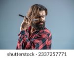 Small photo of Vintage straight razor. Mens haircut. Man in barbershop. Handsome bearded hairdresser is holding a straight razor while barbershop. Straight razor, barbershop, beard.
