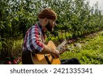 Small photo of Man 's hand playing acoustic guitar, song. Nature background. Guitars acoustic. Male musician playing guitar, music instrument. Man's hands playing acoustic guitar.