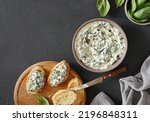 Small photo of Spinach appetizer or dip with bread, top view, dark background, copy space
