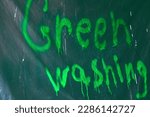 Small photo of Graffiti Graffiti Greenwashing sprayed with green paint on polythene. Deceptive marketing of an ecological product, services or company, brands. High quality photo