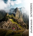 Small photo of Happy young tourist couple are on vacation, with ponchos in Machu Picchu