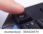 Finger pressing Esc button on computer keyboard