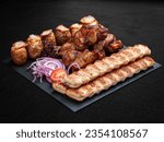 Small photo of A set of grilled meat. Lula kebab, pork gammon, veal steak and baked potatoes. Isolated on a dark background