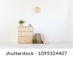 Concept of a cozy interior and housewarming - small wooden chest with accessories and laundry basket on white wall background. Copyspace