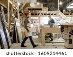 Exposure photography two unidentified young employees of small woodworking and furniture industry working on new furniture collection. Concept of own small successful production
