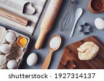 Flat layout composition, baking ingredients and kitchen utensils on a gray background. Culinary trendy background. The concept of making homemade desserts for the holiday.