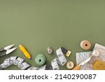 Small photo of Pattern, fabric and sewing accessories on a green paper background, flat, lay, top view, copy space. A tailor or seamstress desk. Sewing concept, background. Tailoring of designer clothes.