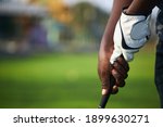 Golfer's hand holds the golf club in preparation for the hit.
