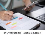 Event planner timetable agenda plan on year 2024 schedule event. Business woman checking planner on mobile phone, taking note on calendar desk on office table. Calendar event plan, work planning