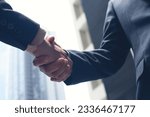 Small photo of Asian businessmen making handshake with buildings in the city as background, business etiquette, congratulation, merger and acquisition, business meeting and partnership concepts