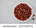 Sichuan pepper. Chinese pepper (Zanthoxylum schinifolium) in bowl on gray stone background. Top view with copy space. Dried spices, Food Ingredients.