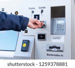 Small photo of A man inserts a credit card into a self service ticket machine in order to purchase a ticket