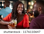 Couple On Date Sitting At Bar Counter And Talking