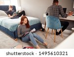 Group Of College Students In Shared House Bedroom Studying Together