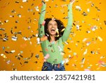 Small photo of Studio Shot Of Excited Woman Celebrating Big Win Showered In Tinsel Confetti On Yellow Background