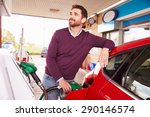 Young man refuelling a car at a petrol station