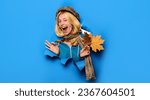 Small photo of Happy autumn girl wink. Cheerful winking woman in cap and scarf showing ok sign. Winking girl with autumn leaves looking through paper. Autumn fashion collection. Autumn sale. Discount. Advertising.
