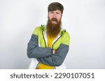 Small photo of red haired man wearing sportswear standing over white studio background expressing disgust, unwillingness, disregard having tensive look frowning face, looking indignant with something.