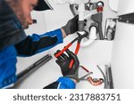 Plumber working in kitchen, Repair man service, repairing leaking water from sinks with red wrench, plumbing  install concept. 