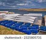 Small photo of Lerwick, UK - May 1 2023: Wind turbine blades and nacelles stored for the Viking Wind Farm, under construction in Shetland, UK. The components await moving to the various construction sites.