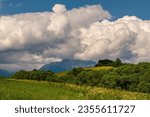 Mountain meadows and fields, sky with white clouds and approaching storm. In the background mountain landscape Krivan peak symbol of Slovakia in Tatras mountains, Slovakia. The beauty of the landscape