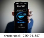 Small photo of Digital chatbot, conversational agents, robot application, conversation assistant that mimic human speech. Hand holding smartphone with digital AI chatterbot on virtual screen for online information.