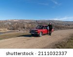 Small photo of Shamakhi, Azerbaijan - January 07 2022- Azeri man in a rural area with red classic sedan car.