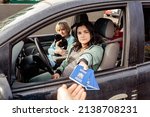 Small photo of Family in car giving Ukrainian passports for custom control crossing border to Europe while fleeing from Ukraine because of Russian invasion. Text on passports: Ukraine Passport