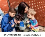 Small photo of Mother with children and cat holding passports fleeing from Ukraine waiting for help and registration in charity center. Text on passports is: Ukraine Passport