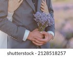 Small photo of A bouquet of lavender in the hands of the groom. A bouquet of lavender in the throes of a man