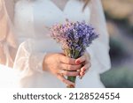 Small photo of A bouquet of lavender in the hands of the bride. Bouquet of lavender in the throes of a woman
