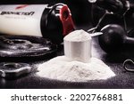 Small photo of spoon with Creatine, whey or casein, whey supplements, protein bar for physical exercises, gym in the background, muscle mass gain