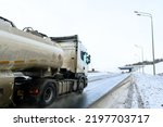 A gasoline tanker, freight truck with gasoline, semi truck, tractor unit and semi-trailer to carry freight. Cargo transportation in harsh winter conditions on slippery, icy and snowy roads.