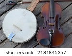 Small photo of Fiddle and Banjo. Fretless clawhammer banjo with Fiddle and bow on a wooden table. Used mostly for old-time music from the Appalachian region of the United States.